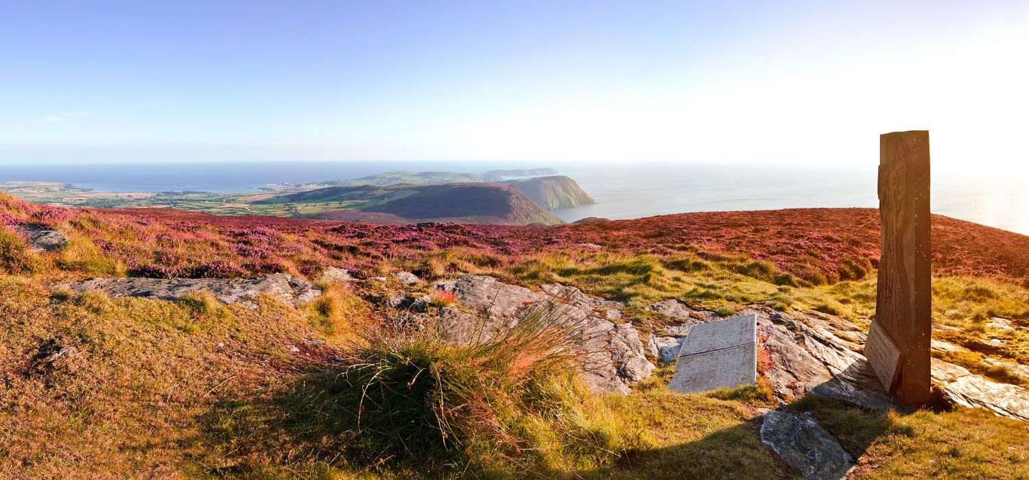 Panorama of South Isle of Man with Celtic Cross - View from Cronk ny Arrey Laa with blooming heather